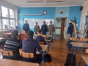 Na zdjęciu policjant i uczniowie.