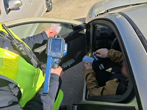 Na zdjęciu policjant podczas kontroli samochodu