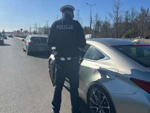 Na zdjęciu policjant podczas kontroli samochodu