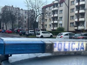 Na zdjęciu policyjny radiowóz, w tle procesja drogi krzyżowej
