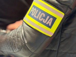 Grafika przedstawia opaskę z napisem POLICJA na ramieniu policjanta