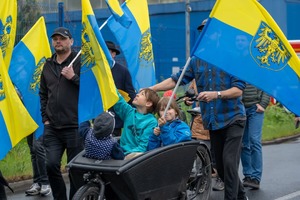 Na zdjęciu dzieci w wózku, mężczyźni i żółto-niebieskie flagi. Źródło: naszemiasto.pl