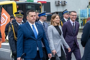Zdjęcie przedstawia dwóch mężczyzn w garniturach, kobietę pomiędzy nimi oraz trzech umundurowanych funkcjonariuszy. Źródło: naszemiasto.pl