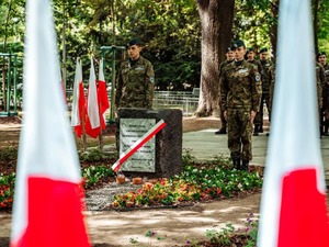 Na zdjęciu uczniowie klasy mundurowej i tablica pamiątkowa