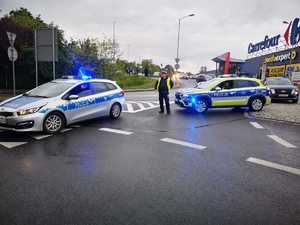 Na zdjęciu policjanci kierujący ruchem i radiowozy