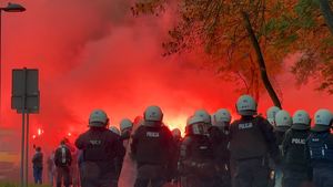 Na zdjęciu zbliżenie na policjantów stojący tyłem na tle czerwono niebieskiego dymu
