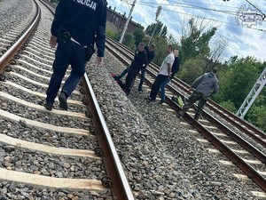 Na zdjęciu tory kolejowe. Dwóch sprawców. Trzech policjantów w ubraniach cywilnych oraz jeden umundurowany policjant.