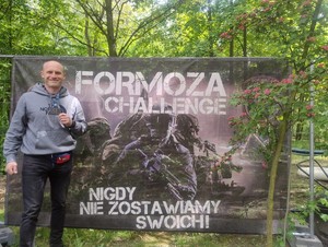 Na zdjęciu młodszy aspirant Łukasz Graniczny na tle plakatu Formoza Chellenge