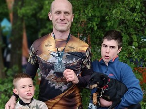 Na zdjęciu Łukasz Graniczny z medalem oraz z dwoma synami i psem