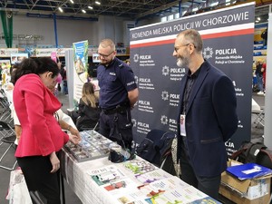 Na zdjęciu policjant przy stoisku Komendy Miejskiej Policji w Chorzowie oraz kobieta i mężczyzna