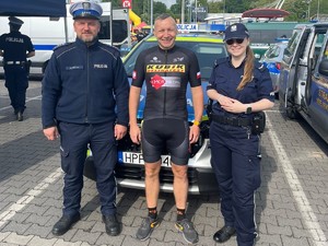 Na zdjęciu policjant z policjantka oraz policjant z Tomaszem dzierga pośrodku