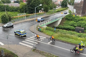 Na zdjęciu radiowóz prowadzący rowerzystów na trasie przejazdu