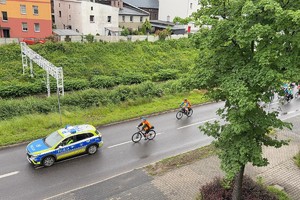 Na zdjęciu radiowóz prowadzący rowerzystów na trasie przejazdu
