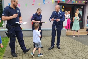 Na zdjęciu policjanci wręczający dzieciom medale