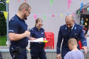 Na zdjęciu policjanci wręczający dzieciom medale