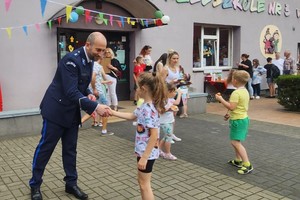 Na zdjęciu policjanci wręczający dzieciom medale