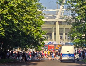 fotografia przedstawia kibiców i radiowóz na tle stadionu śląskiego