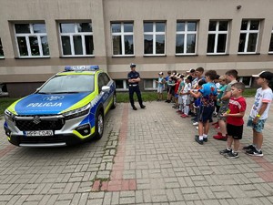Na zdjęciu radiowóz i grupa dzieci