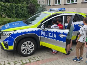 Na zdjęciu radiowóz i grupa dzieci