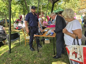 Na zdjęciu policjant przy stosiku profilaktycznym mężczyzna i dwie kobiety