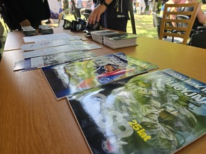 Na zdjęciu stoisko profilaktyczne z gazetami POLICJA i goglami oraz innymi broszura i policyjnymi